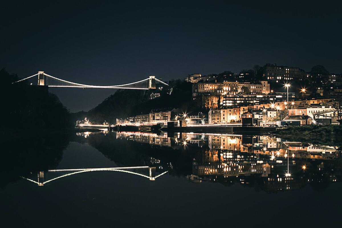 Night time image overlooking a river and buildings