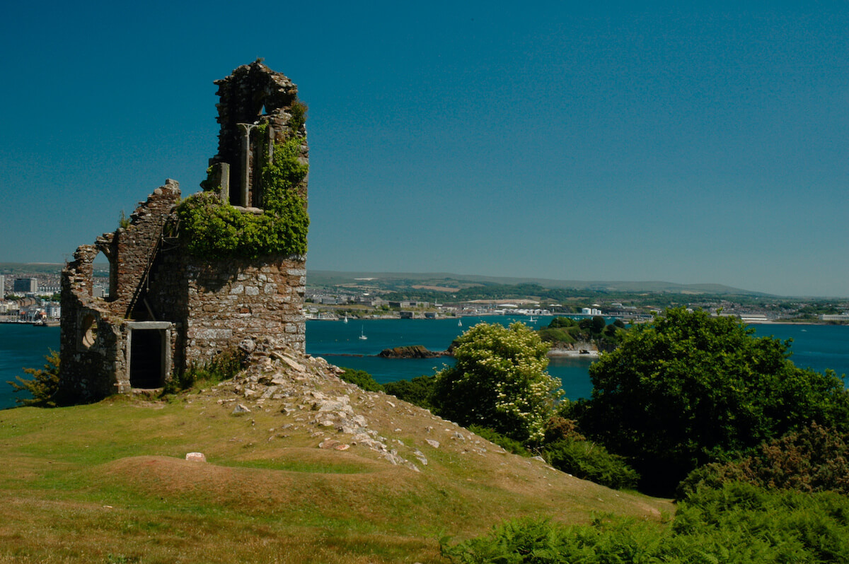 Ruined building on top of a hill looking over a harbour